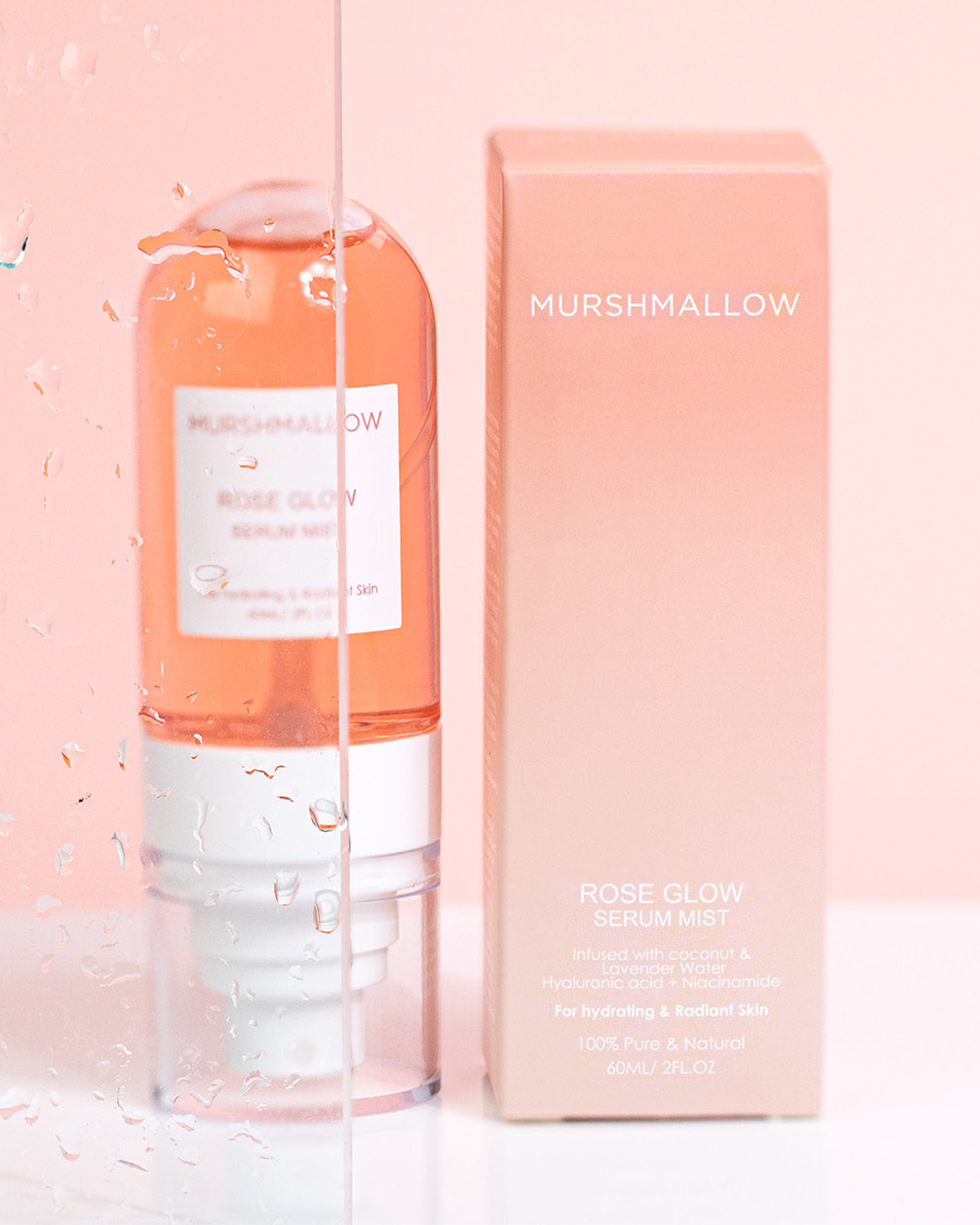Murshmallow Rose Glow Serum Mist product shot; clear serum bottle with white label and dispenser next to its pink box with text.